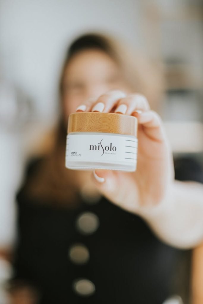Close-up image of a woman holding a misolo skincare product with a focus on the cosmetic jar.