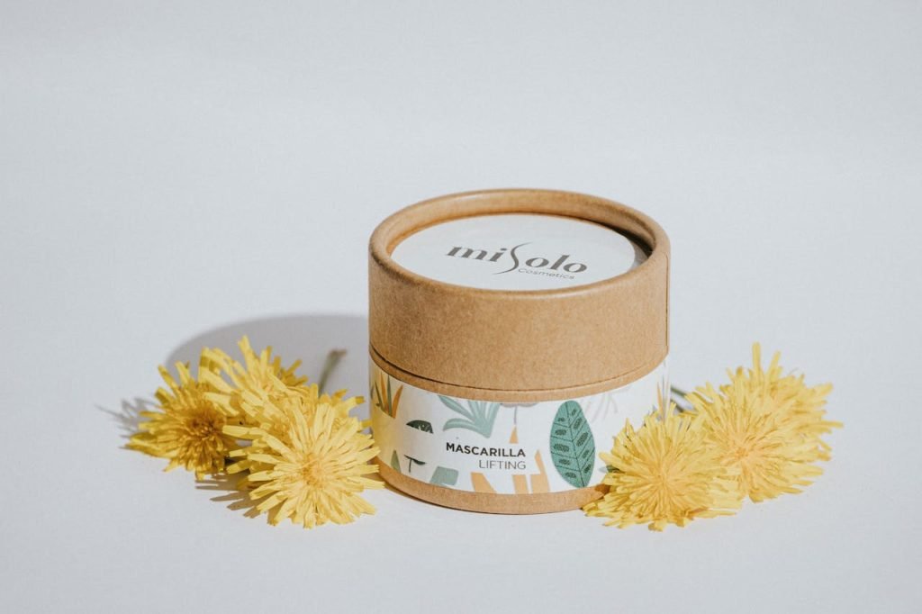Sustainable skincare packaging with dandelions in a minimalist setup.